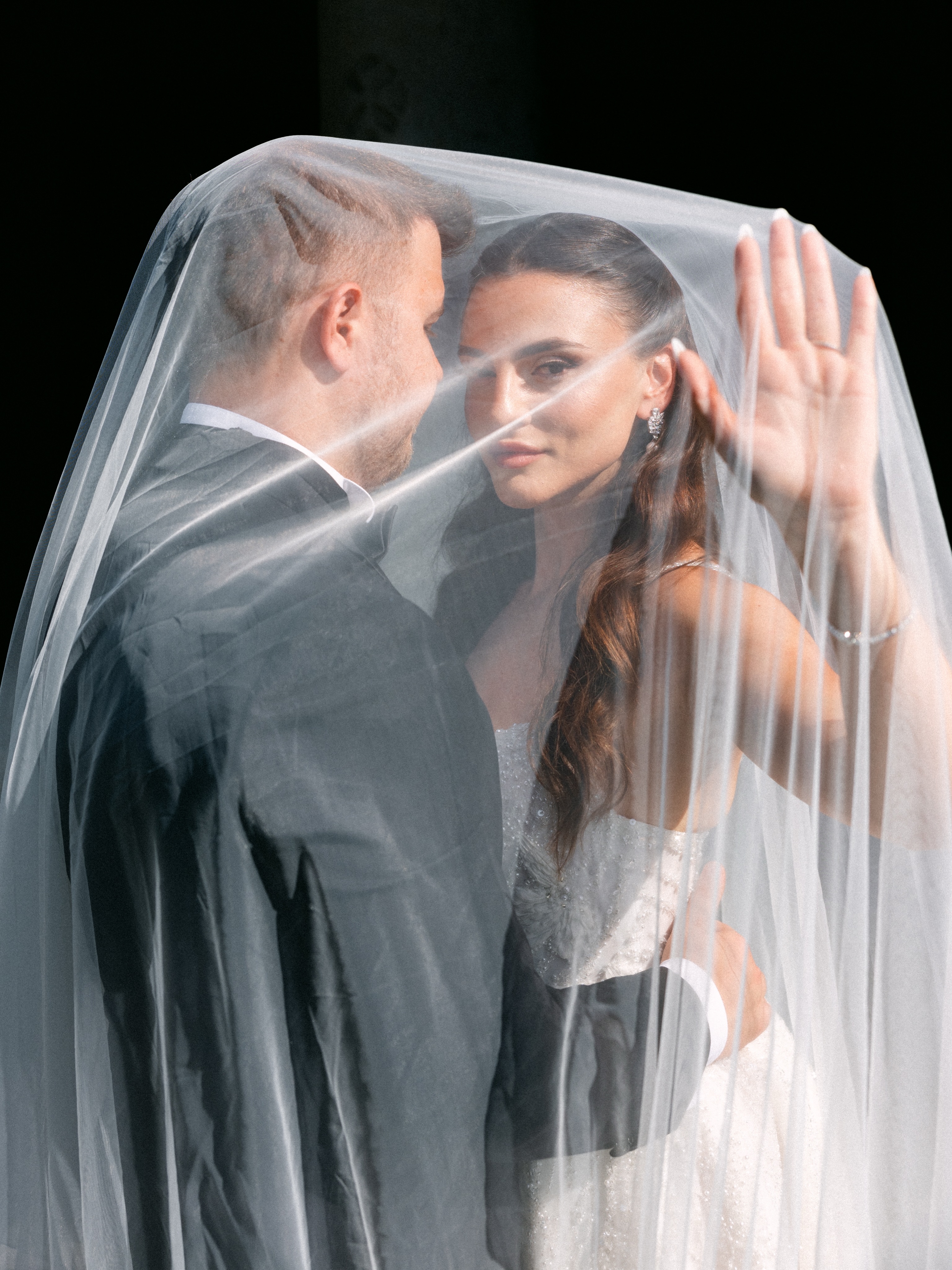 Newlyweds sharing a quiet moment beneath the bride's veil