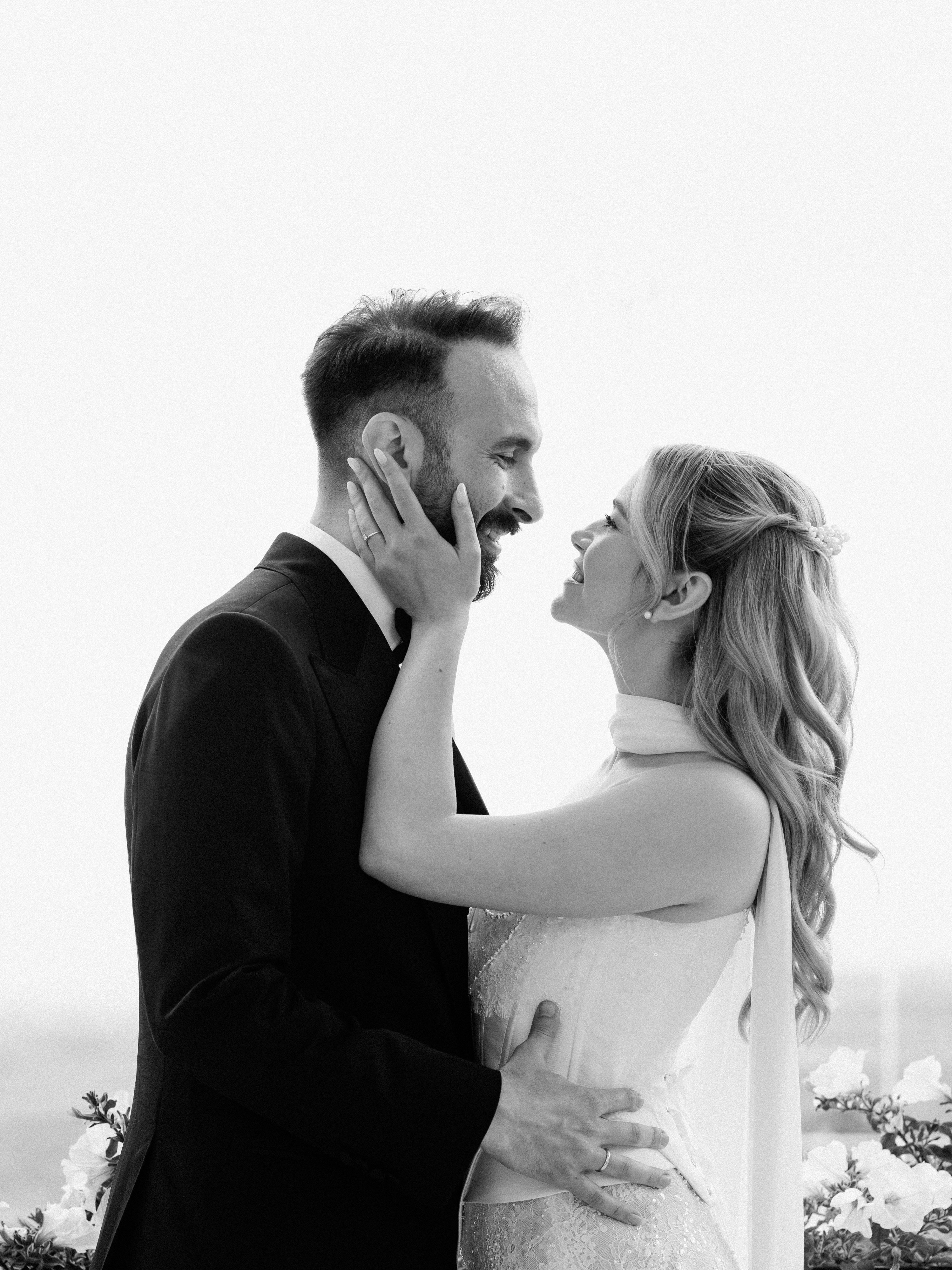 Newlyweds sharing a joyful black-and-white portrait